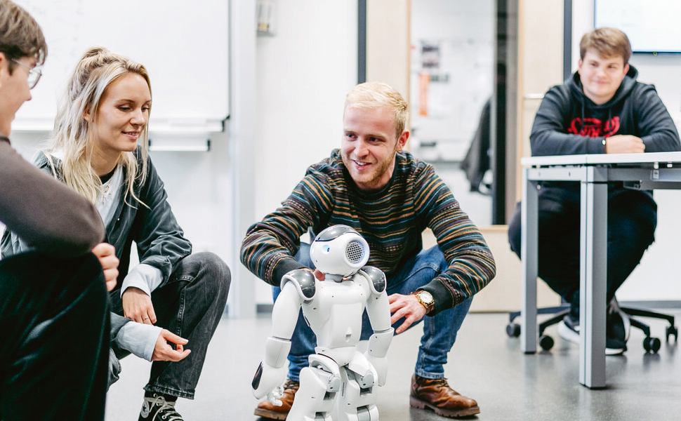 Studenten mit einem Roboter in einem Seminarraum