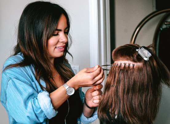 Eine Friseur-Azubine frisiert ein Haarmodell.